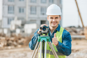 Pictured is a civil engineer performing a portion of a land survey.